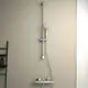 Brausethermostat mit Brausestange von Ideal Standard, ausgestattet mit einer flexiblen Duschbrause und Temperatureinstellung, montiert an einer hellen Wand.